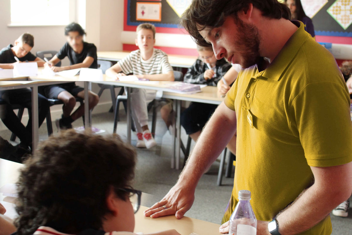 معلم إنجليزي يساعد طالباً في الفصل